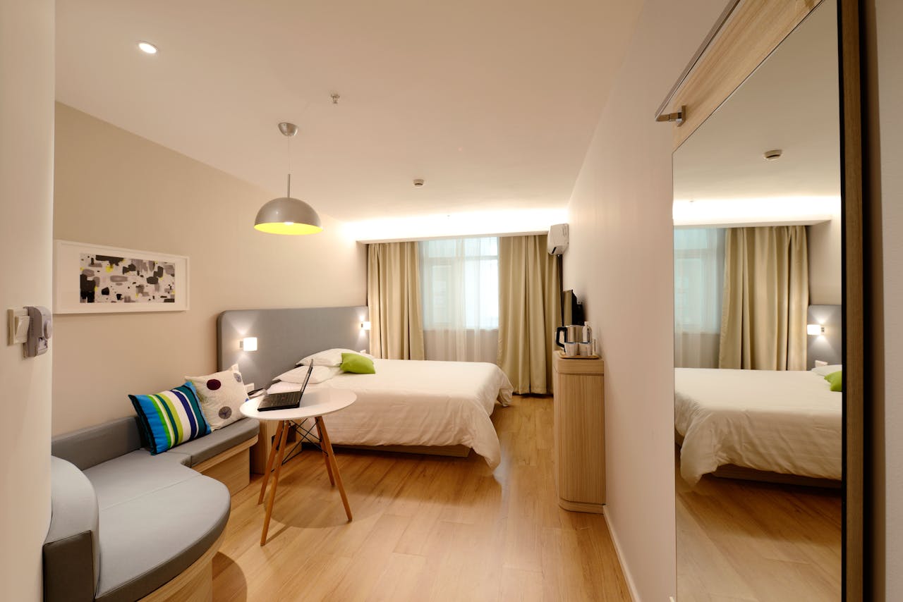 collection-04 Spacious modern hotel room featuring cozy decor and neutral tones with natural light.
