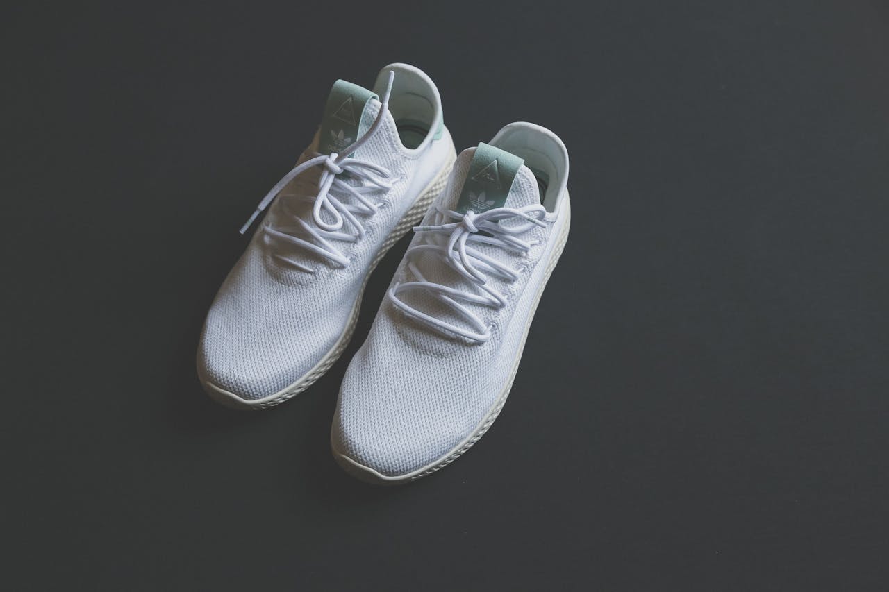 bedroom-bliss White mesh sneakers with laces shot from above against a dark surface.